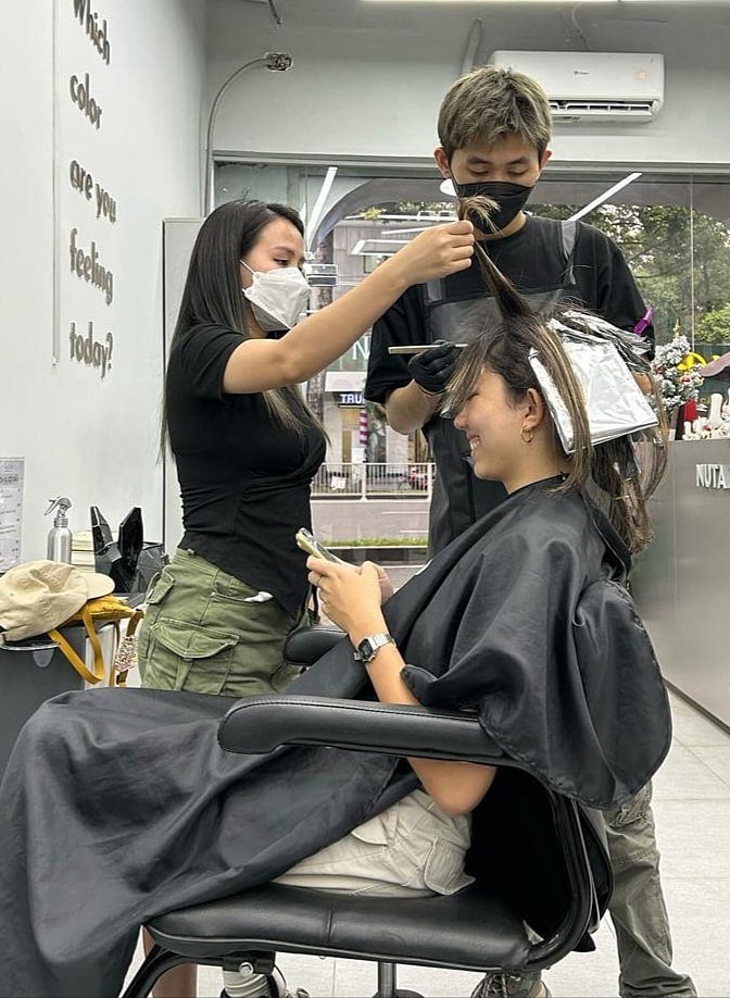 Du khách Singapore làm tóc tại một tiệm ở quận 1 với giá 1,4 triệu đồng cho dịch vụ cắt, nhuộm. Ảnh: Xianne