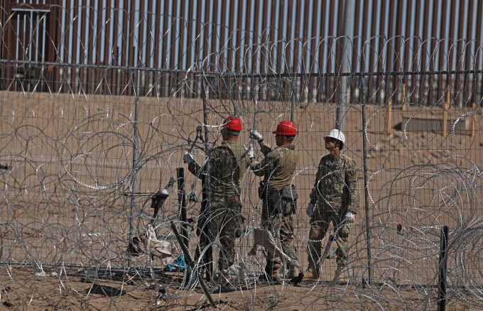 Các kỹ sư  Lực lượng Vệ binh Quốc gia Texas dựng hàng rào dây thép trên bờ sông Rio Grande để ngăn người di cư từ Mexico ngày 4/3. Ảnh: AFP